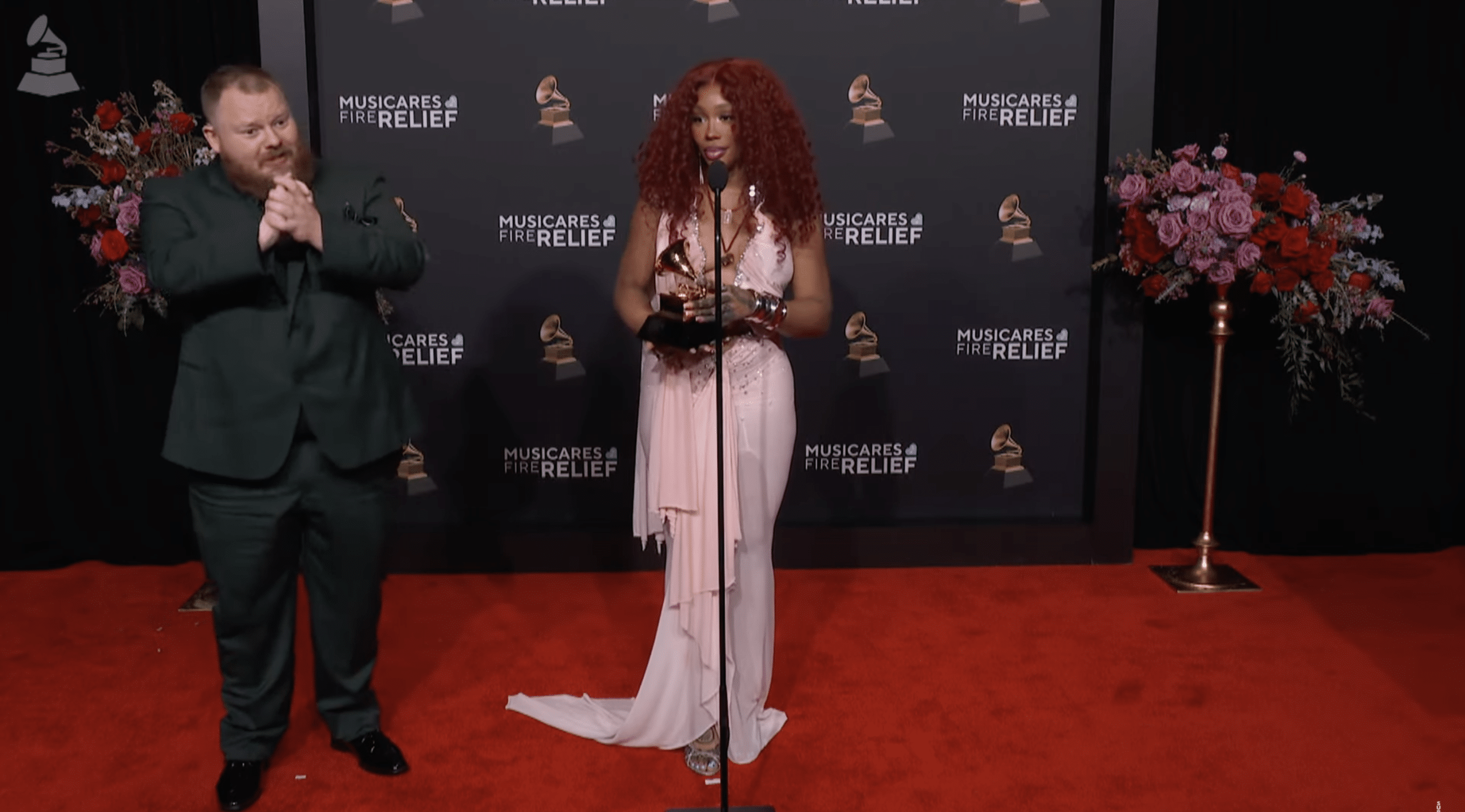 SZA stands with interpreter as she answers questions at the Pre-Grammys